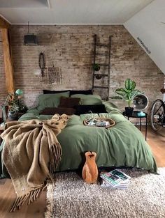 a bedroom with exposed brick walls and green linens on the bed, along with a bicycle