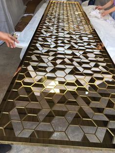 people standing around a table that has been made out of wood and gold foil on it