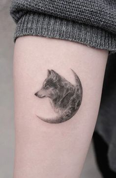 a small wolf tattoo on the right inner arm and leg, with a half moon behind it