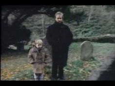 two people standing next to each other in front of a grave