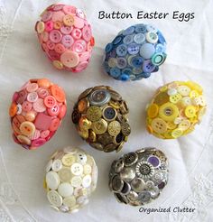 six different colored buttons sitting on top of a white cloth covered table next to each other