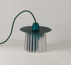 a green lamp with a cord attached to it