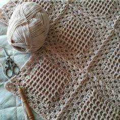 a ball of yarn sitting on top of a blanket next to scissors