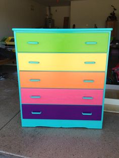 a multicolored dresser is sitting on the floor