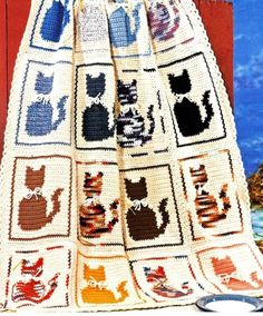 an old crocheted blanket with cats on it