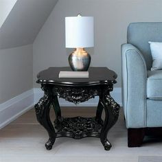 a black table with a lamp on it next to a blue chair in a room