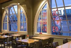 an empty restaurant with tables and chairs in front of large windows that say do the right thing