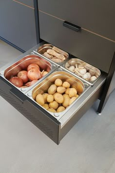 four trays of food sitting on top of a counter next to an open drawer