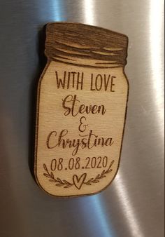 a wooden magnet with a mason jar on it that says, with love between christmas and new year