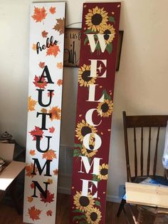 two wooden signs with the words welcome and autumn painted on them next to a chair