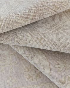 the textured fabric is beige and has an intricate design on it, as well as two