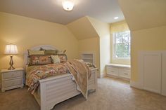 a bedroom with yellow walls and carpeted flooring