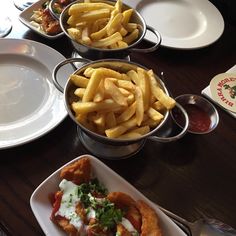 there are many different types of food on the table and one has fries in it