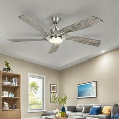 a living room with a couch, coffee table and ceiling fan in the middle of it