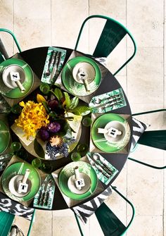 an overhead view of a table with green chairs and flowers in the center surrounded by dollar bills