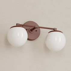 two light fixtures mounted on the side of a wall