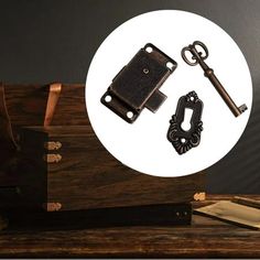 a wooden box with an antique key and lock on the lid next to a book