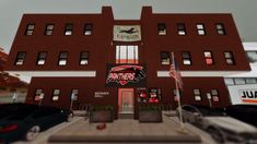 the front of a building with cars parked in front of it and an american flag flying outside