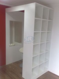 an empty room with white shelving and red walls