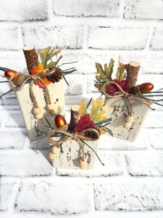 three wooden blocks decorated with fall leaves and acorns are sitting on a brick wall