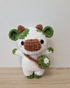 a crocheted stuffed animal holding a flower