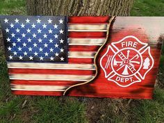 an american flag painted on wood with a fire department emblem