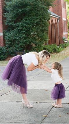 a mother and her daughter playing on the sidewalk