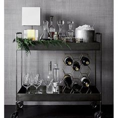 a bar cart filled with wine glasses and silverware