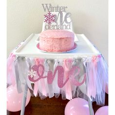 a pink cake sitting on top of a table