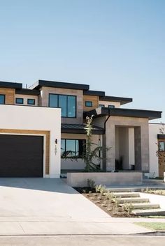 a large house with two garages and steps leading up to it