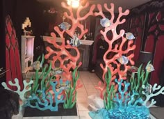 two fake corals are sitting on the floor in front of a mirror with fish