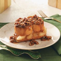 a white plate topped with two pieces of cake covered in pecans and caramel