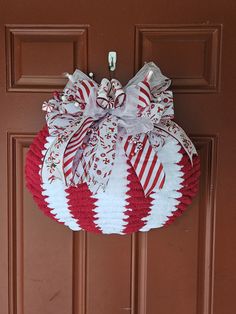 a red and white wreath hanging on the front door