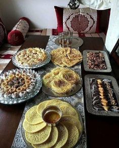 a table topped with lots of desserts and pastries on top of trays