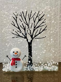 a snowman is standing next to a tree