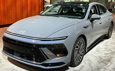 a gray car is on display at an auto show