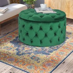 a living room with a green ottoman and rug