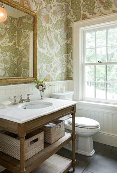 a bathroom with a sink, mirror and toilet in it's center island next to a window