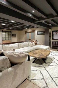 a living room filled with furniture and a flat screen tv mounted to the wall next to a wooden coffee table