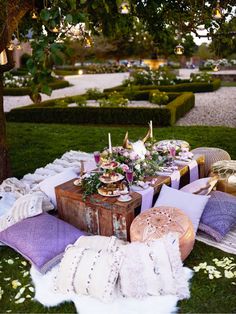 the table is set up with pillows and other items for an outdoor dinner or party