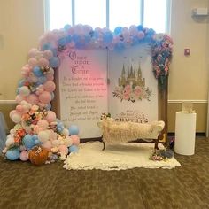 a decorated stage set up with balloons, flowers and a bench in front of it