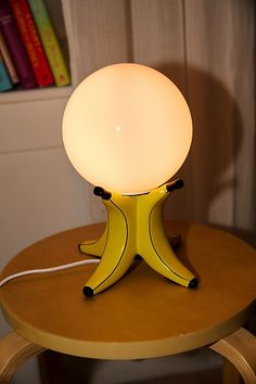 a yellow table lamp sitting on top of a wooden table