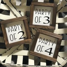 three wooden frames with numbers on them are sitting in a wicker basket that says party of 3