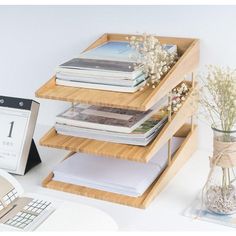 a stack of books sitting on top of a wooden shelf next to a laptop computer