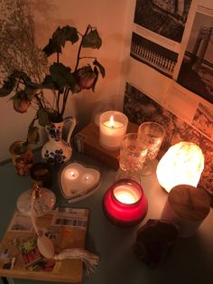 some candles are on a table with pictures and other things in the room around them