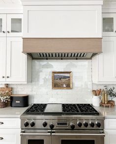 a stove top oven sitting inside of a kitchen next to white cabinets and counter tops