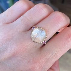 This morganite is a showstopper, that is for sure. The pink side Sapphires make this beauty pop. It is set in 14k yellow gold and is finished on a hand textured sterling silver band. Approx Stone Size: 13mm x 12mm Approx Ct Weight: 8.7 ct Mohs Stone Hardness: 7.5-8 This one of a kind piece is handmade with love in Emily's Hudson Valley studio. If you have questions about sizing, shipping or need help deciding on your perfect piece please reach out to us! Rose Gold Topaz Ring With Morganite And Accent Stones, Morganite Pink Gold Rings With Accent Stones, Pink Gold Morganite Rings With Accent Stones, Heirloom Morganite Jewelry In Yellow Gold, Yellow Gold Oval Morganite Sapphire Ring, Oval Morganite Jewelry In Pink Gold, Morganite Rings With Accent Stones, Pink Sapphire Multi-stone Gold Jewelry, Gold Multi-stone Pink Sapphire Jewelry