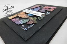 a close up of a black card with butterflies on it and a tag that says congratulations