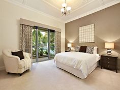 a bedroom with a bed, chair and sliding glass doors