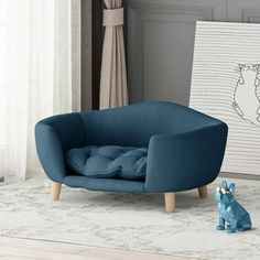 a blue chair sitting on top of a rug next to a dog figurine